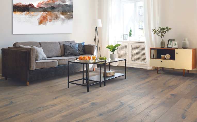 warm honey toned wood look laminate flooring in a bright bedroom